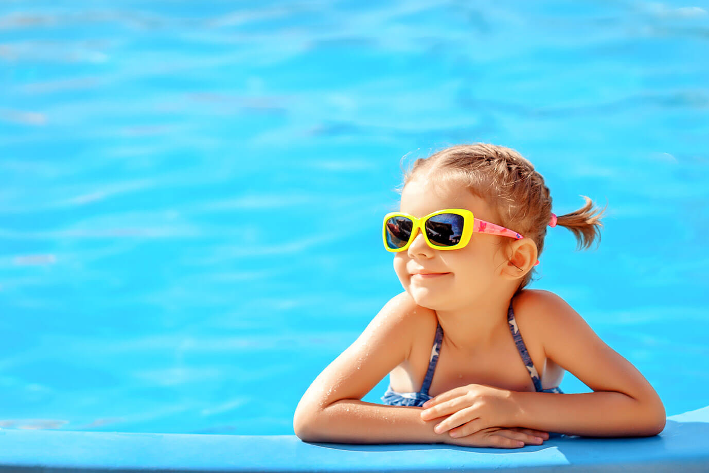 young girl resting on a float in a pool