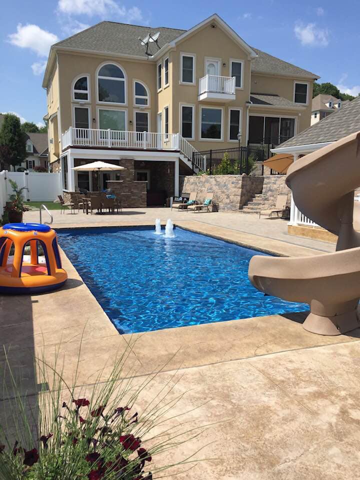 inground pool ledge in a backyard