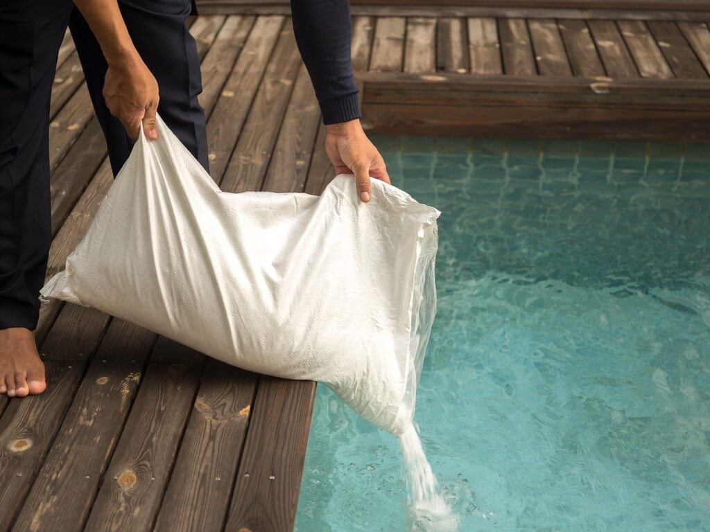 man dumping salt in a Saltwater Pool