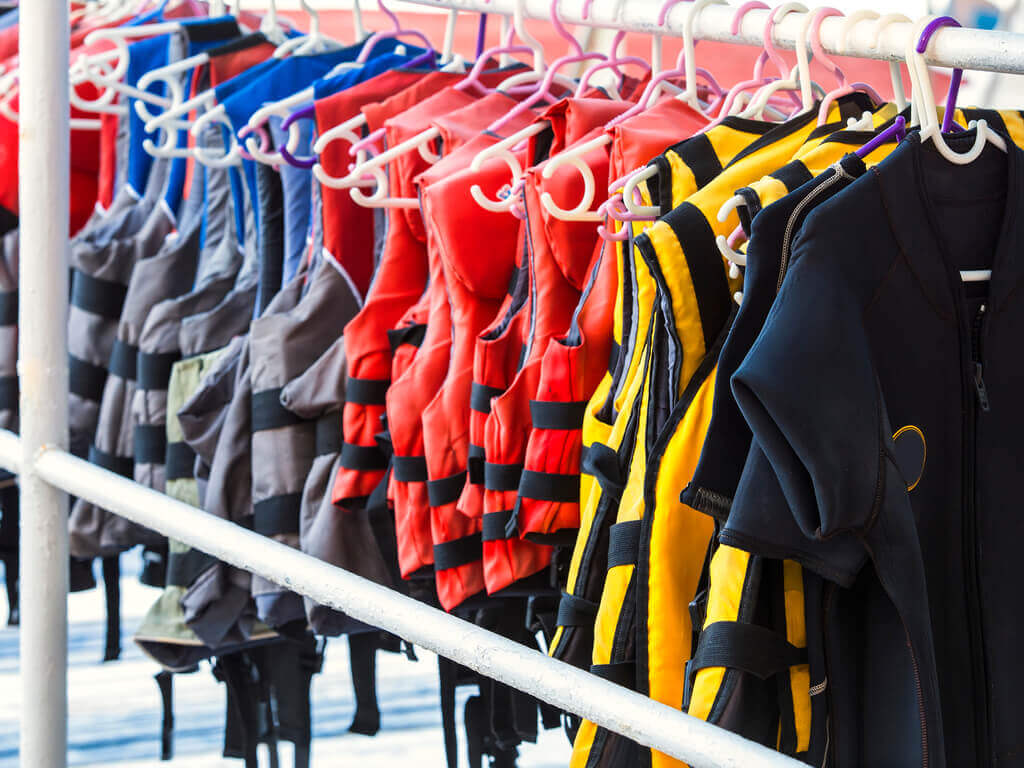various personal flotation devices hung on rack